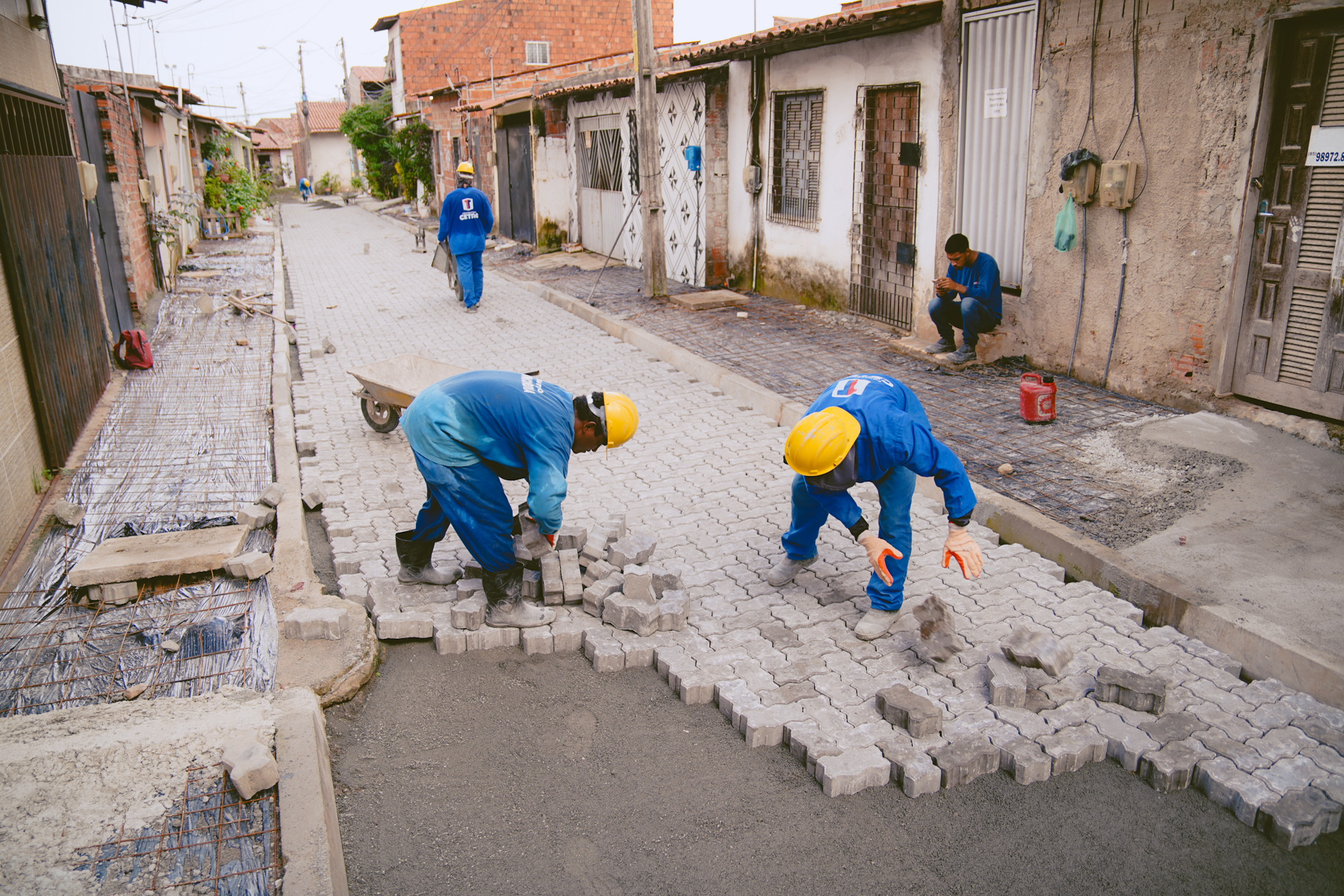 operário colocando piso intertravado numa via